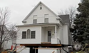 Older farmhouse raised off its foundation on cribbing