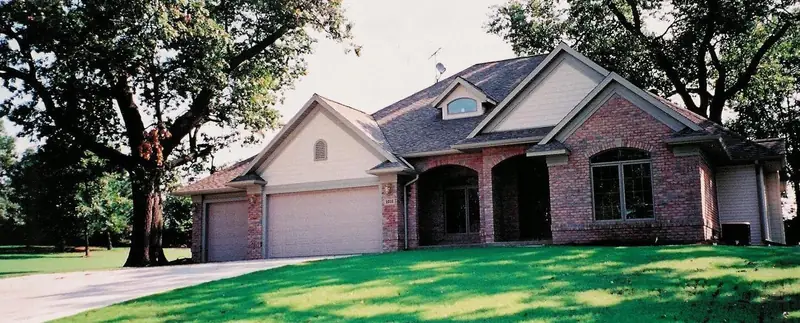 Finished brick ranch home with a green lawn