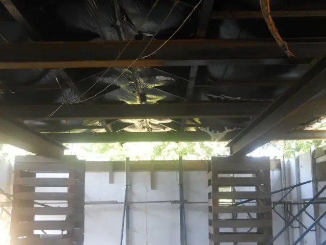 Inside a basement with ICF walls and floor joists overhead