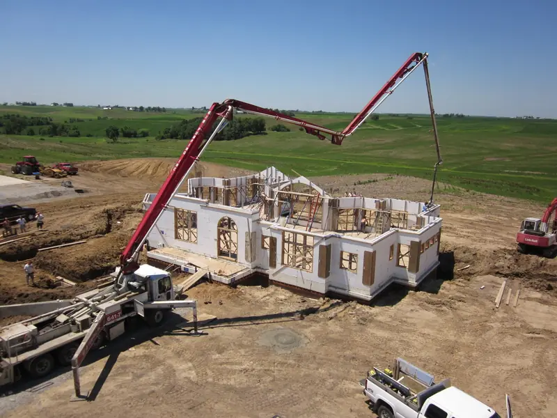 Large ICF home walls being poured with a pump truck boom