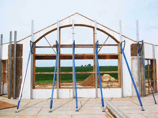 ICF walls with an arched opening held plumb by blue panel jack bracing