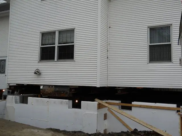 New insulated concrete form foundation walls being built under a lifted house